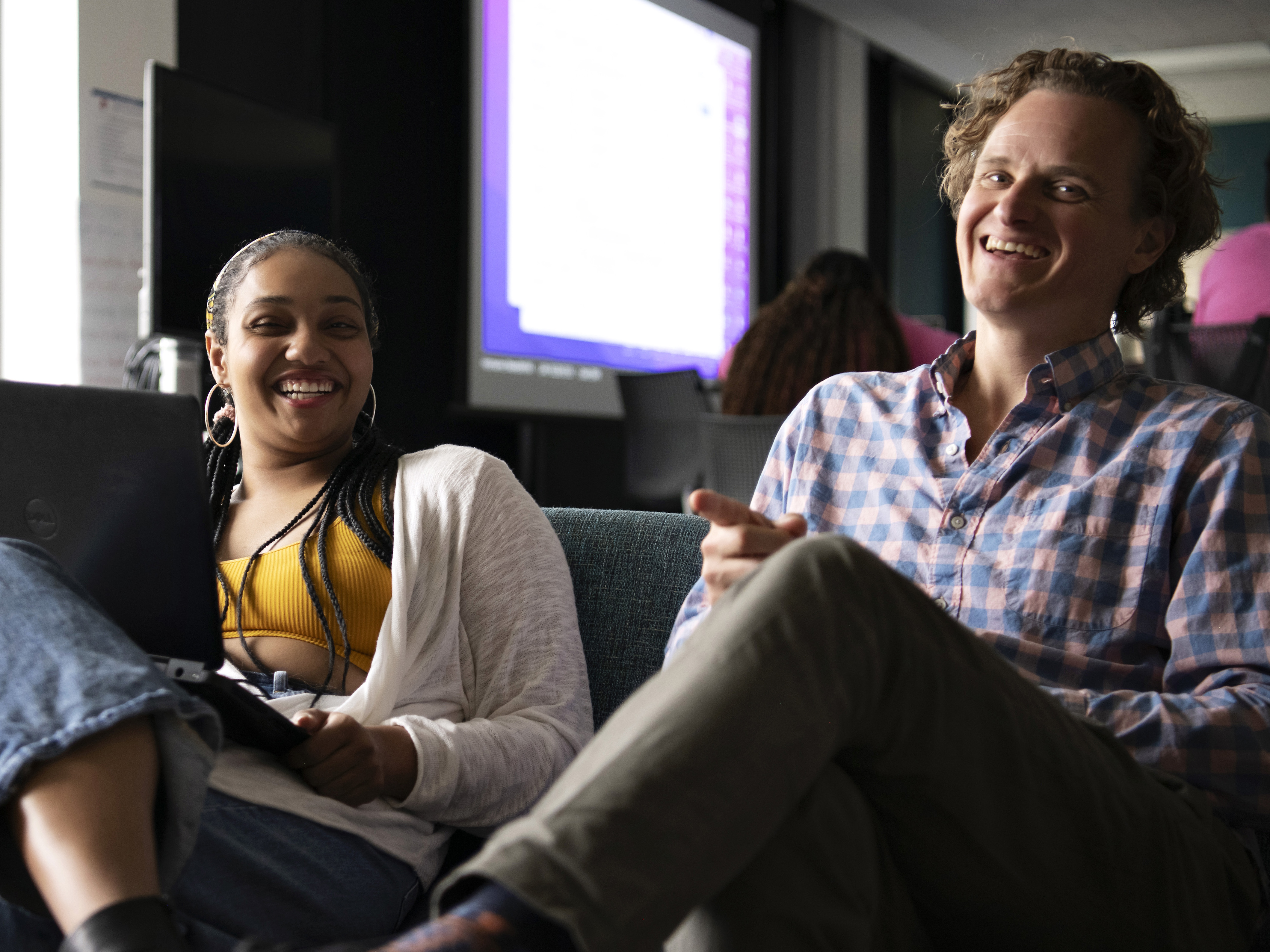 A faculty mentor holds a meeting with a Drake student to discuss a paper in a campus common area