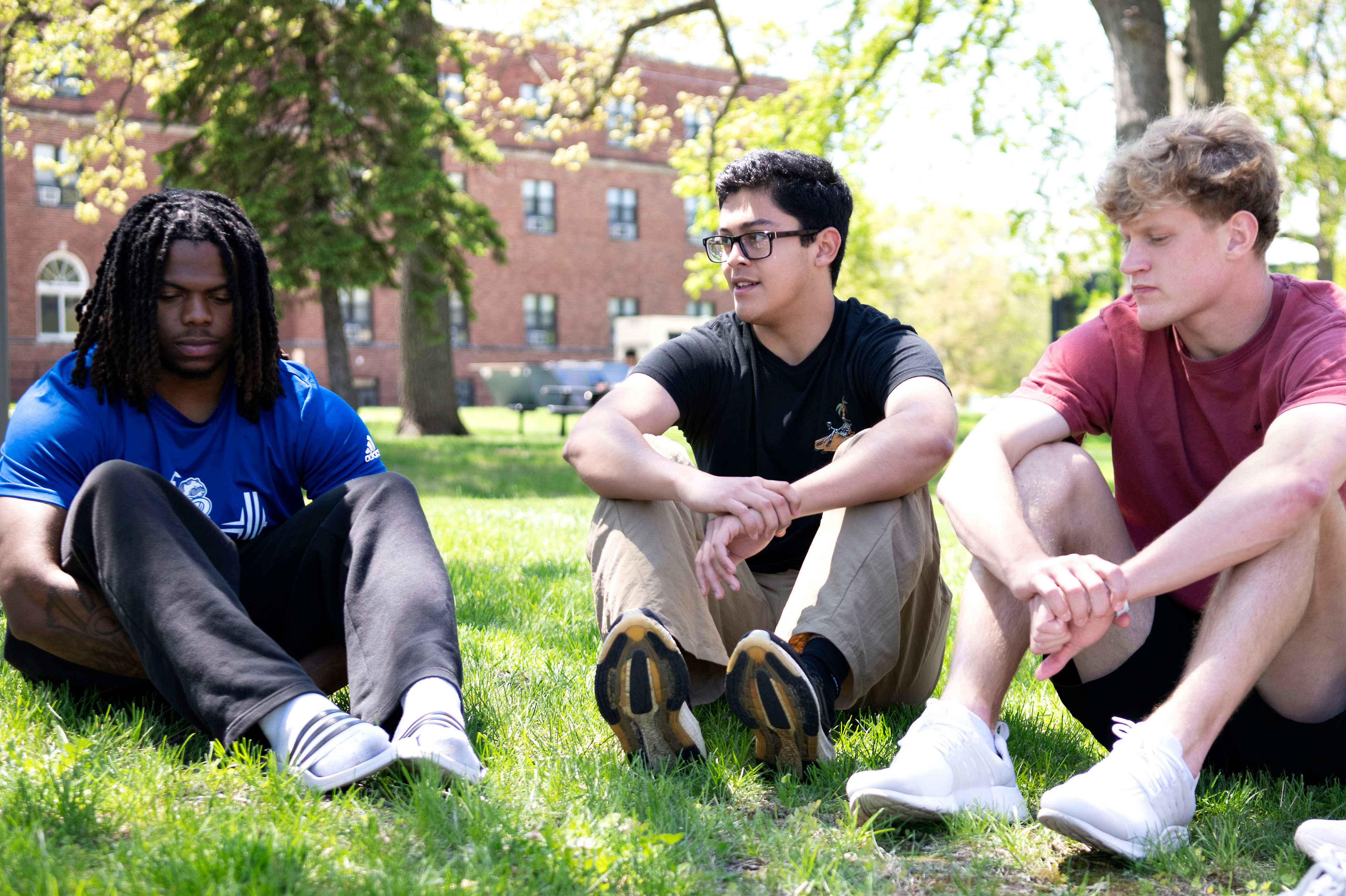 Drake students sit outdoors in a circle for a group introductory activity as part of the First-Year Seminar