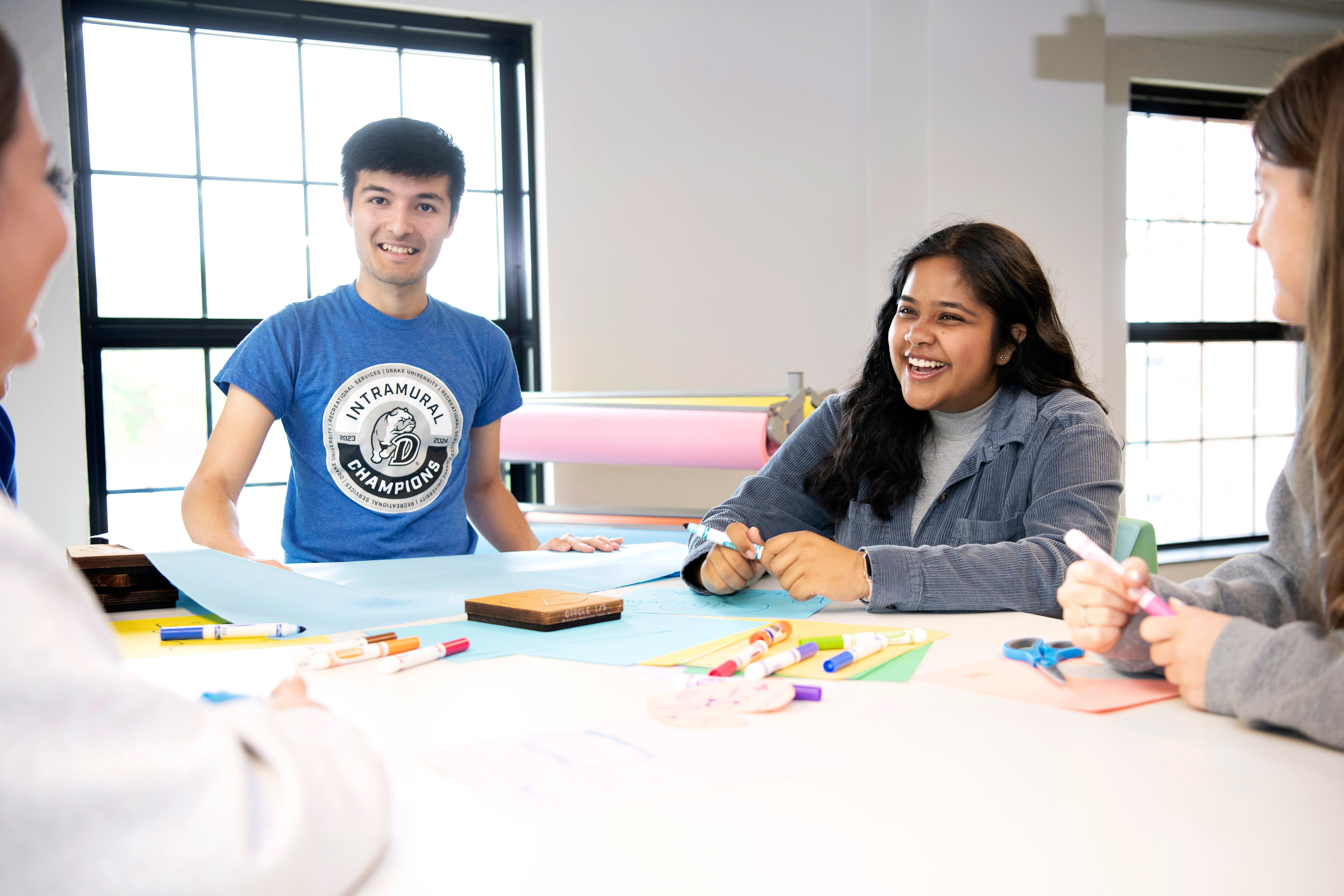 During a meeting for Impact Explorers, older students tell Drake first-years about the resources available on campus, as they color with paper and markers