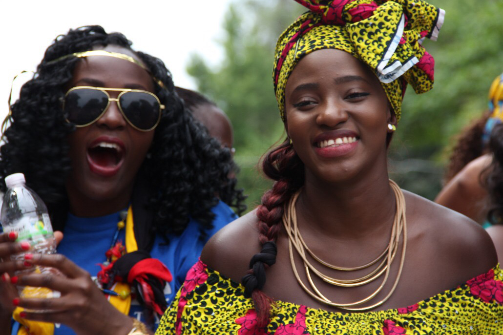 Drake students in colorful clothing and sunglasses enjoy themselves at an outdoor cultural event on campus