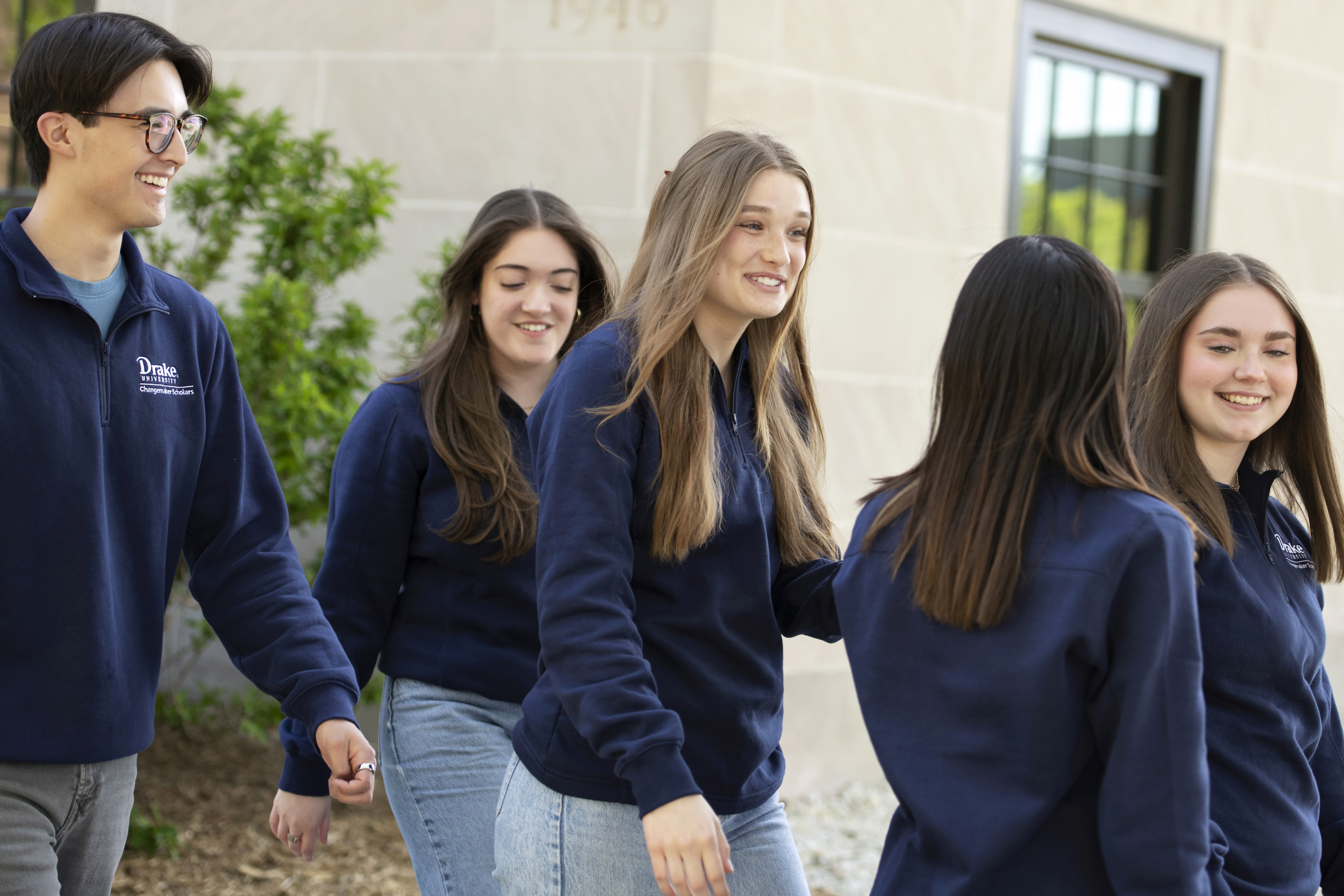 Drake students in navy blue sweatshirts head outdoors for a team leadership event