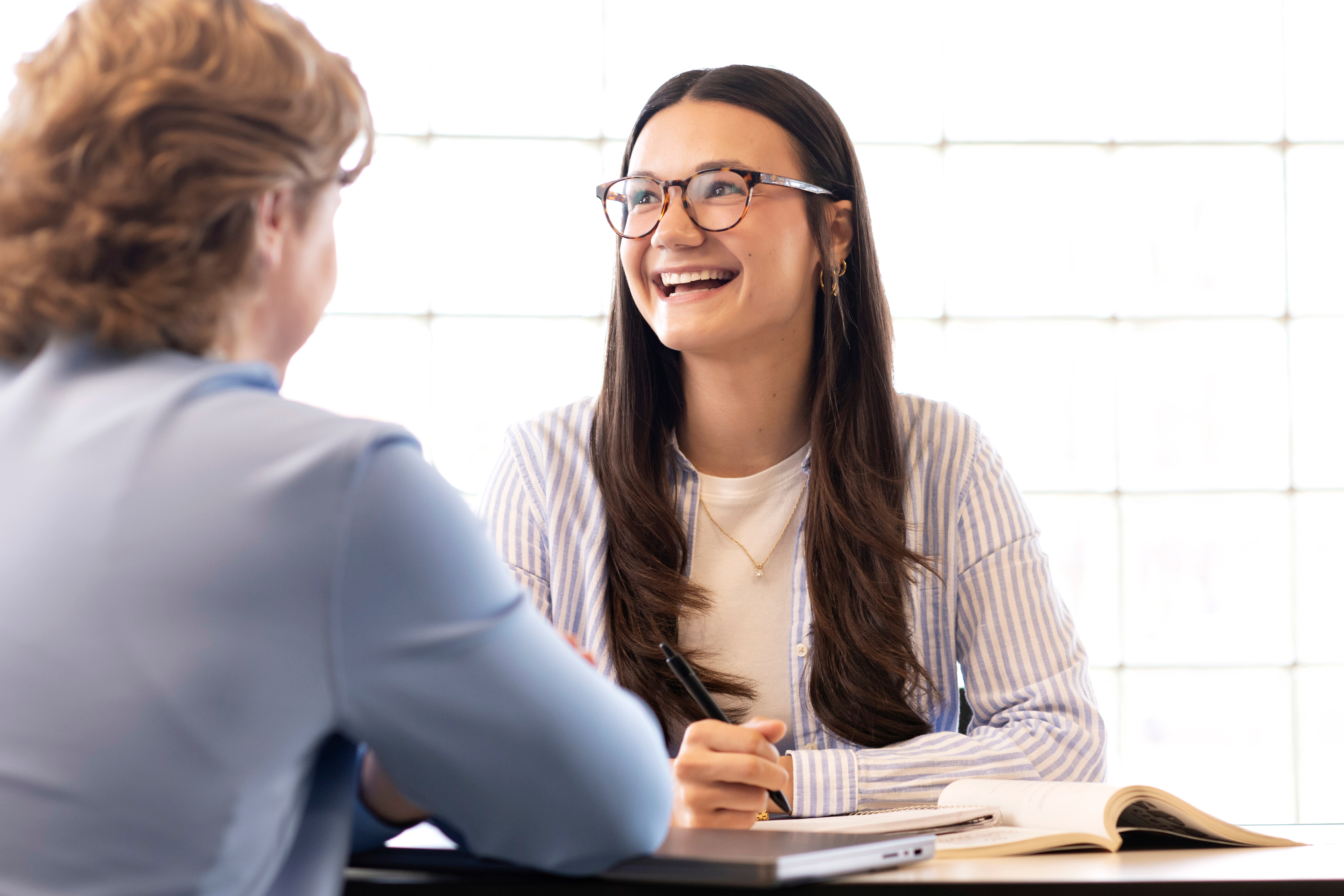 A Drake graduate student meets with a counselor to discuss possible careers in a room where light passes through glass bricks