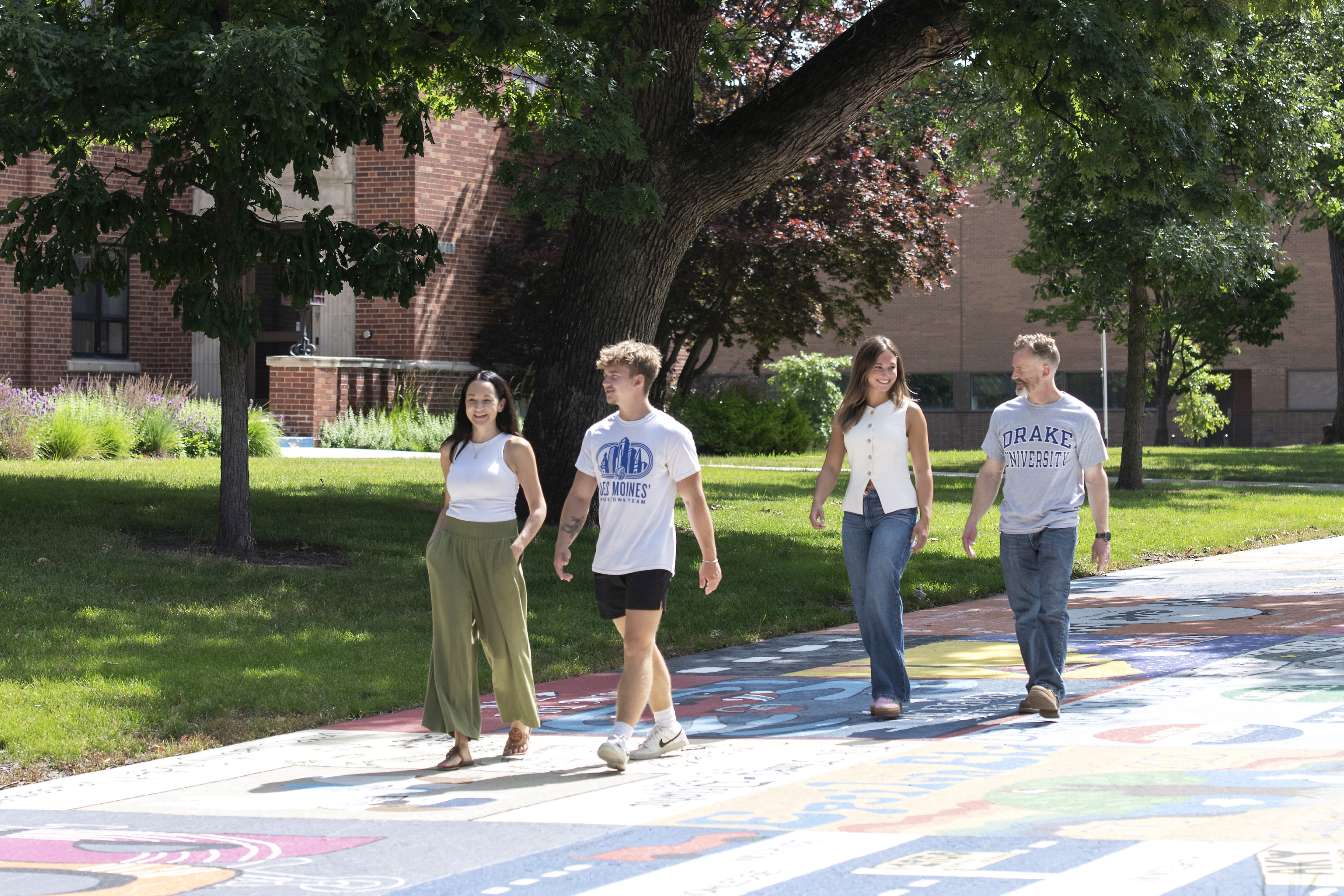 A small campus tour passes an area of the Drake campus where a colorful mural was painted on the ground