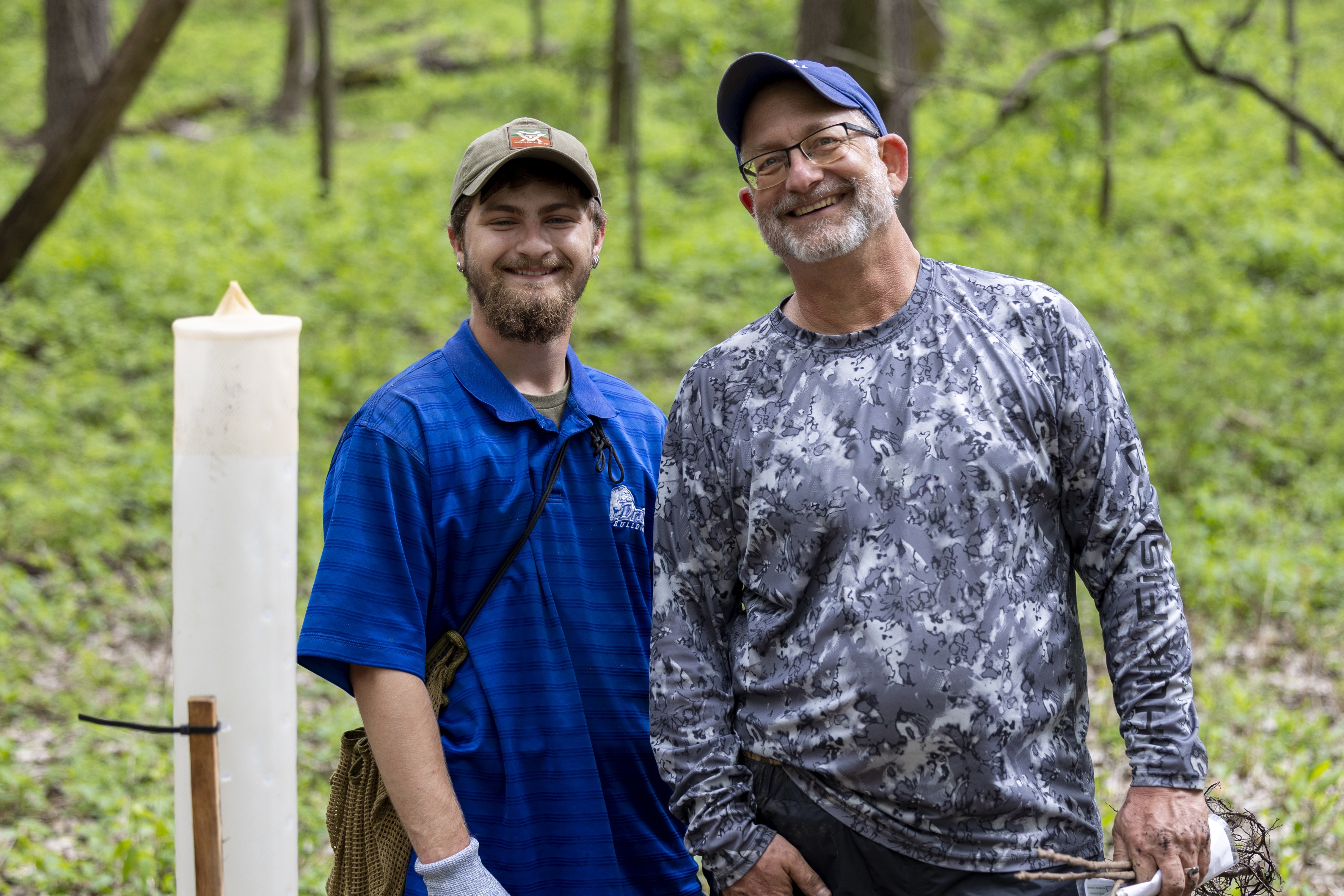 Two people standing in the woods