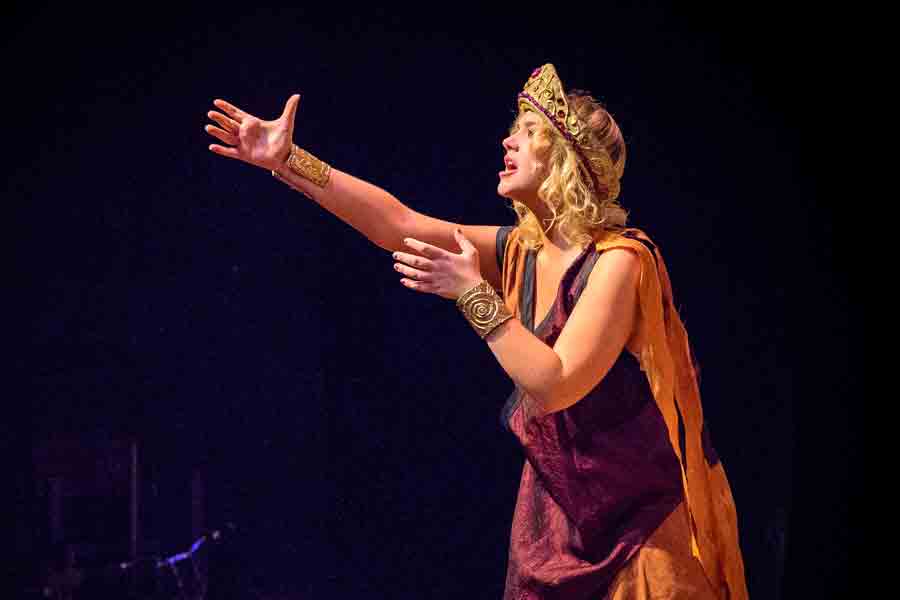  A student in costume acting on stage during a production