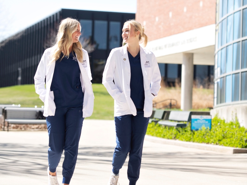 Two Drake pharmacy students walk through campus and laugh together