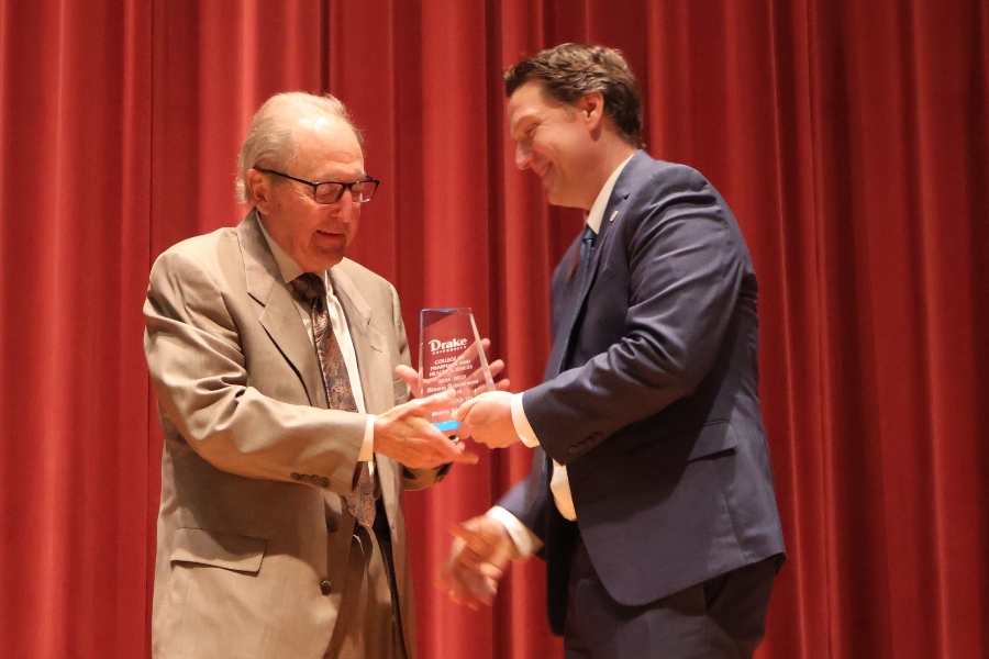 A Drake alumni shakes the hand of the Dean as he accepts his award