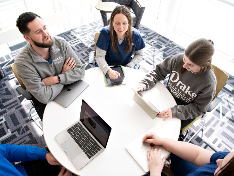 A group of students enrolled in Drake's College of Pharmacy and Health Sciences meet around a table for a professional group