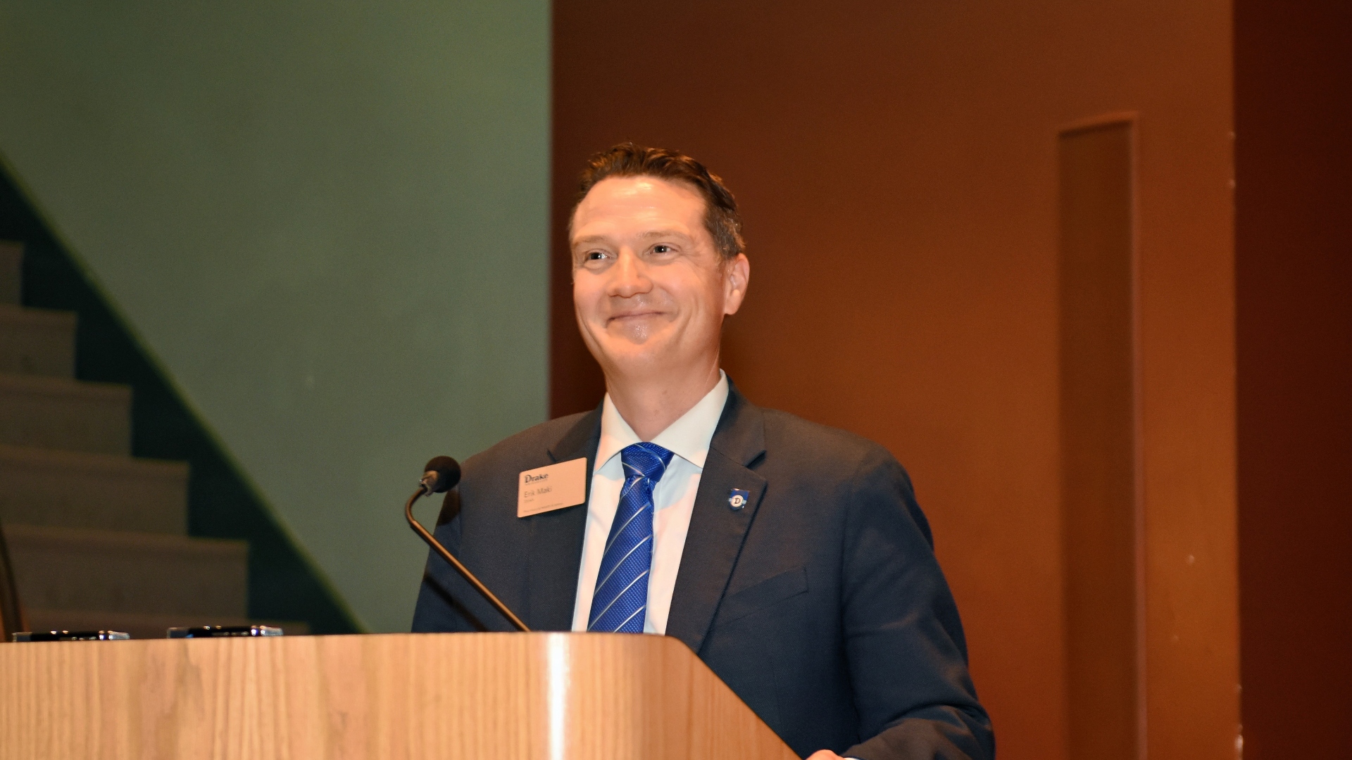 Dean Maki speaking at a podium
