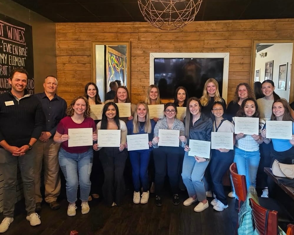 A large group of Drake leadership students hold award certificates at a celebration