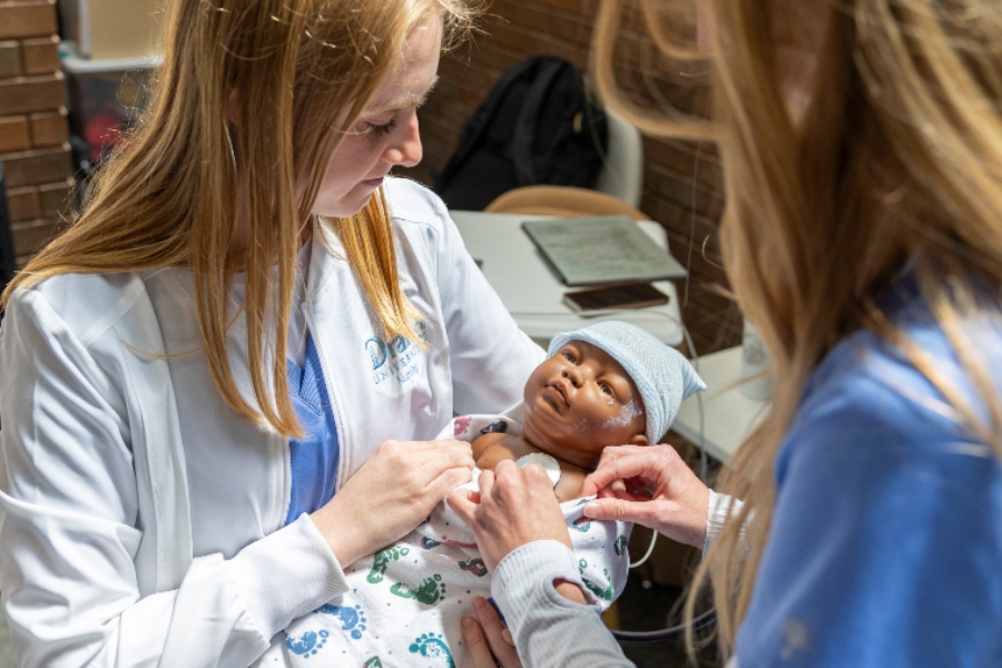 Drake nursing students inspect a baby doll