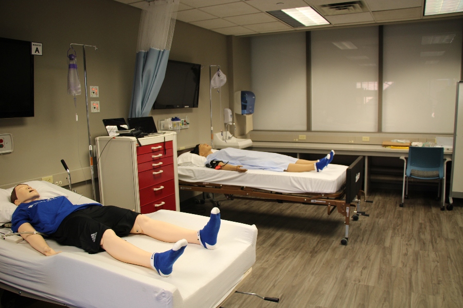 Simulation lab with two mannequins on hospital beds with medical equipment
