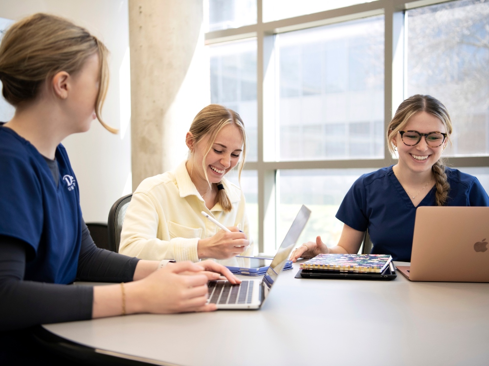 Drake pharmacy students laugh and study together with their tablets and computers