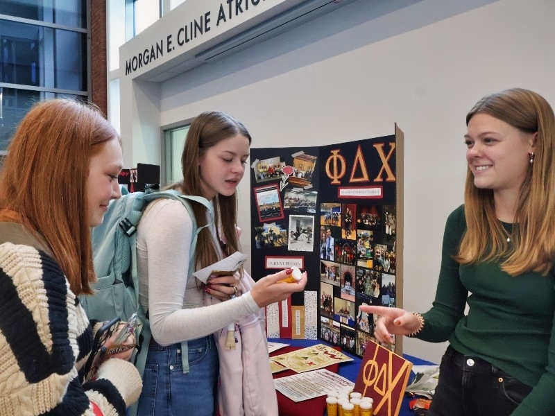 Drake pharmacy students visit a pharmacy fraternity booth at the student engagement fair