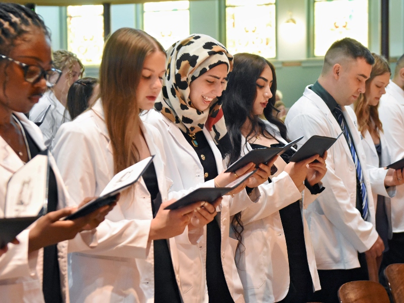 Pharmacy students read their pledge of professionalism at the white coat ceremony