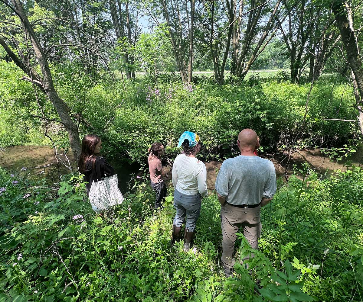 Four individuals inspecting a creek in Dubuque County.