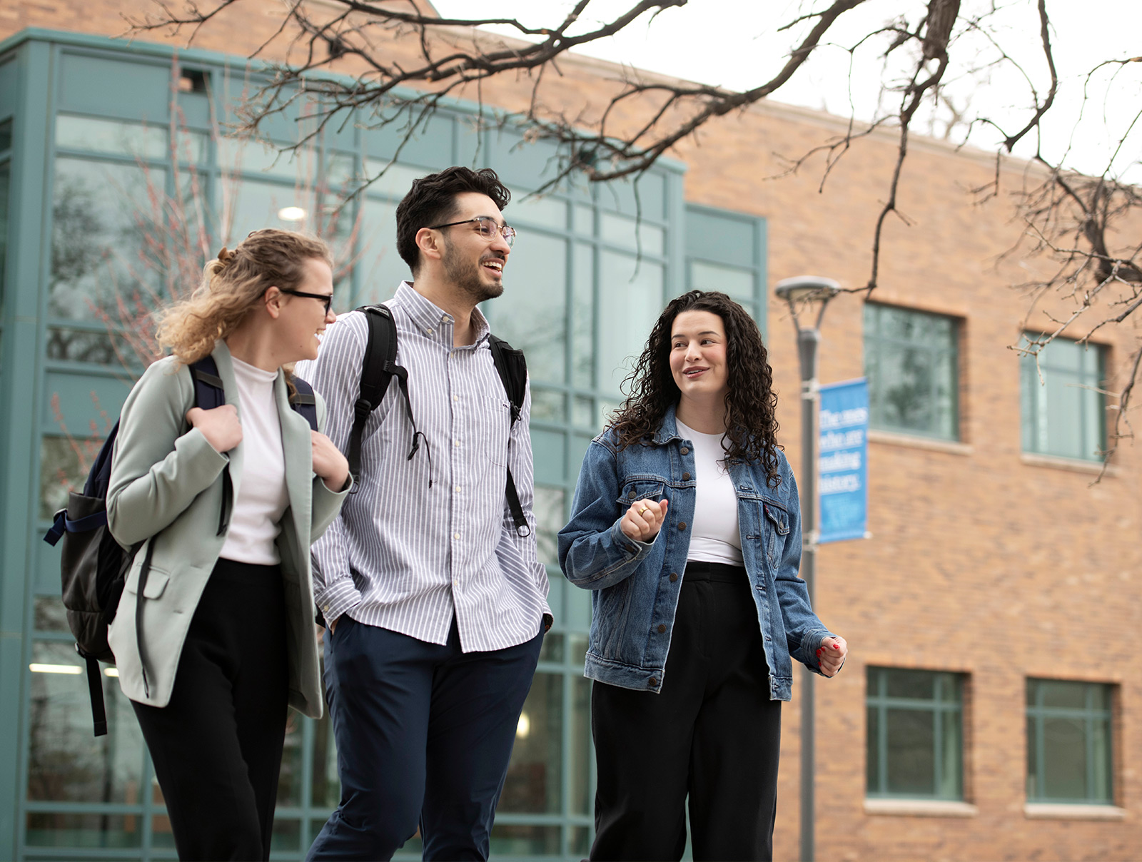 Three Drake University Law School students walking together outside of Cartwright Hall.