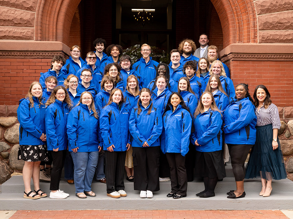 49 graduating seniors completing the Adams Leadership Institute in May 2026, standing together as a group in front of Old Main