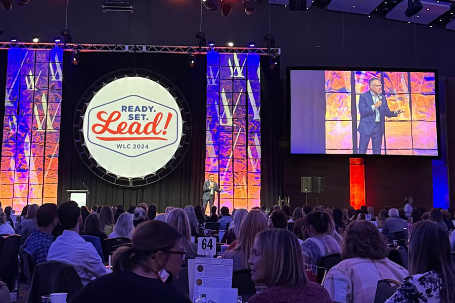 Ready. Set. Lead! WLC 2024 Conference, with speaker on stage talking.