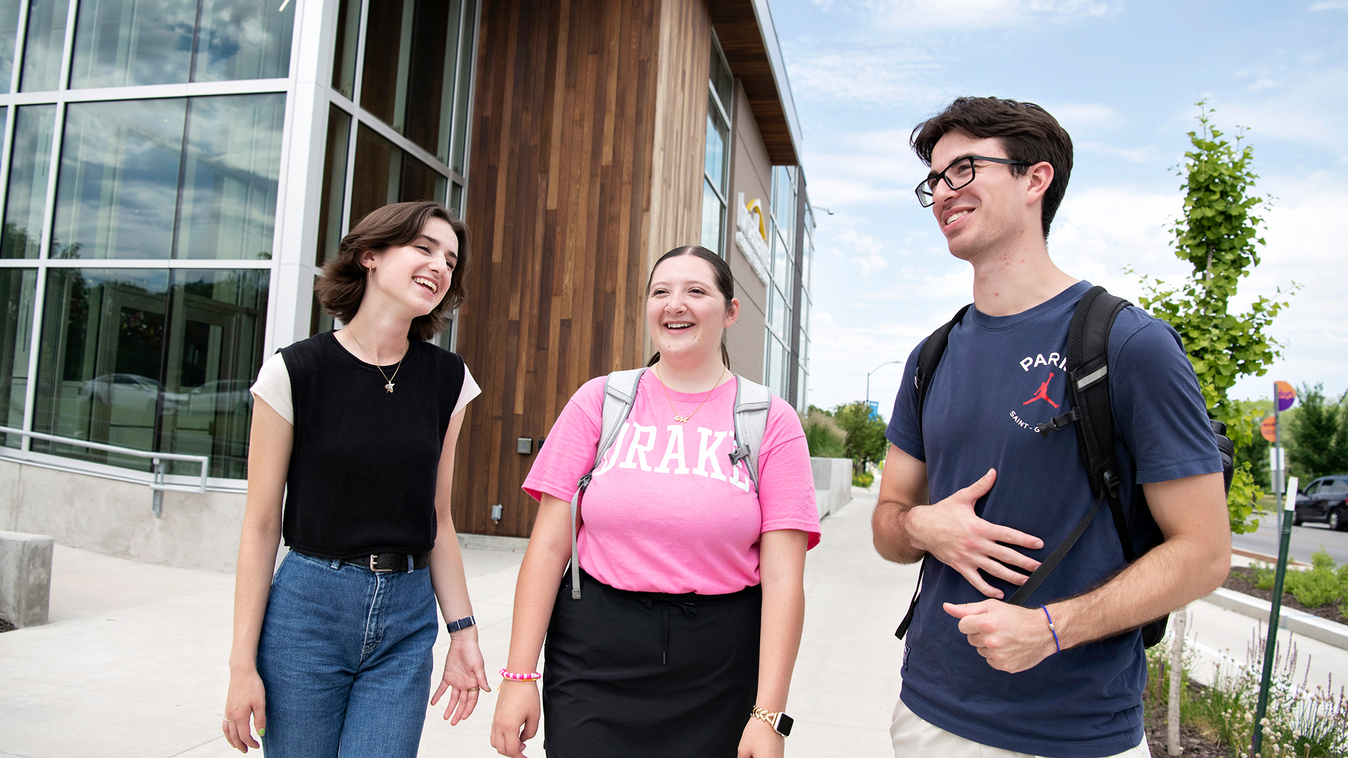 Three students smile in a group outside Drake University's Counseling Center