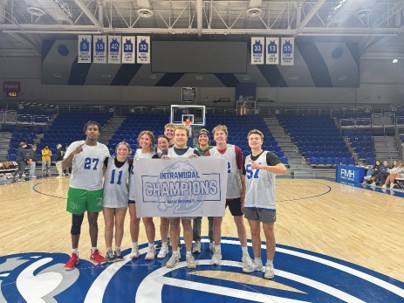 Students on a basketball court holding a sign