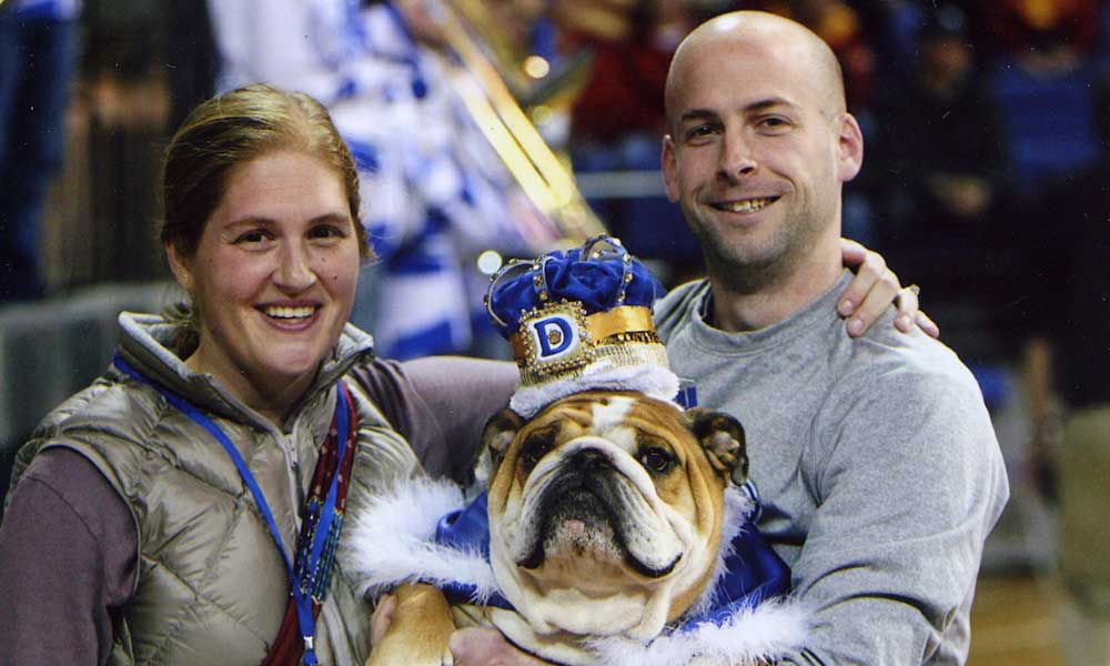 Porterhouse at the Beautiful Bulldog Contest after winning in his cape and crown with his owners Erin and Kevin.