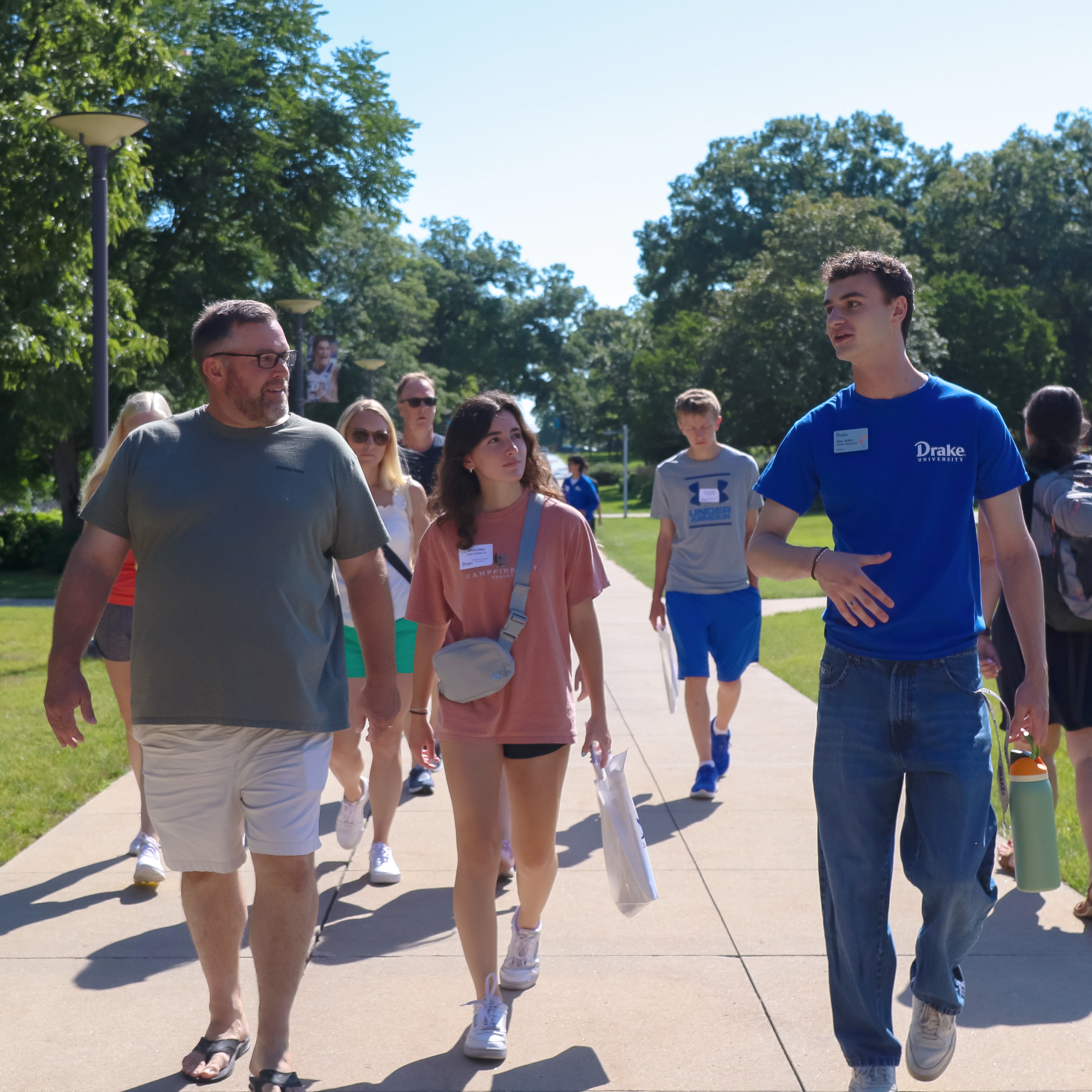 A Drake student guides a group of new students and their families through campus
