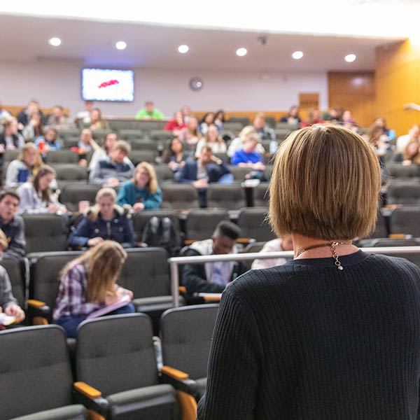 Instructor teaching to a lecture hall of Drake University students.