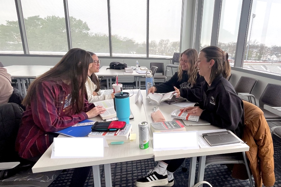 four cohort members working together at a table