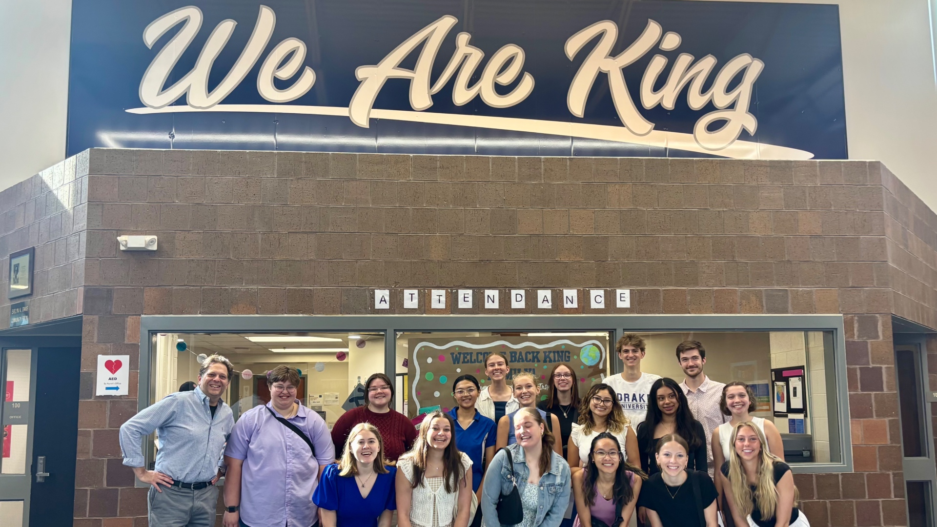 Drake Elementary Ed students posing in front of the King Elementary attendance desk during their first practicum experience