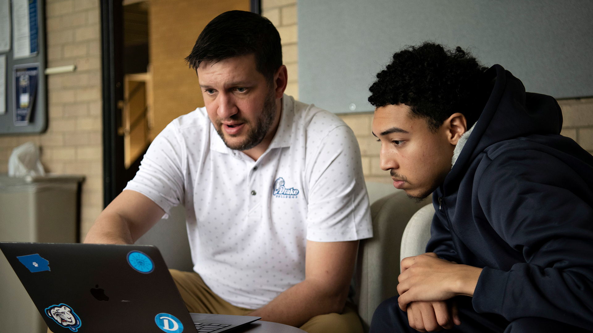 A faculty member helps a student in Drake's A.A. in Business, Organization, and Professional Studies program with an assignment
