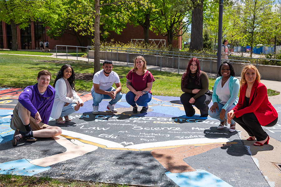 Students from Drake's A.A. in Integrated Arts, Sciences, and Humanities program show off the mural they created on campus