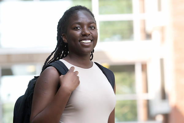 A Drake Actuarial Science student holds a strap on their backpack while smiling