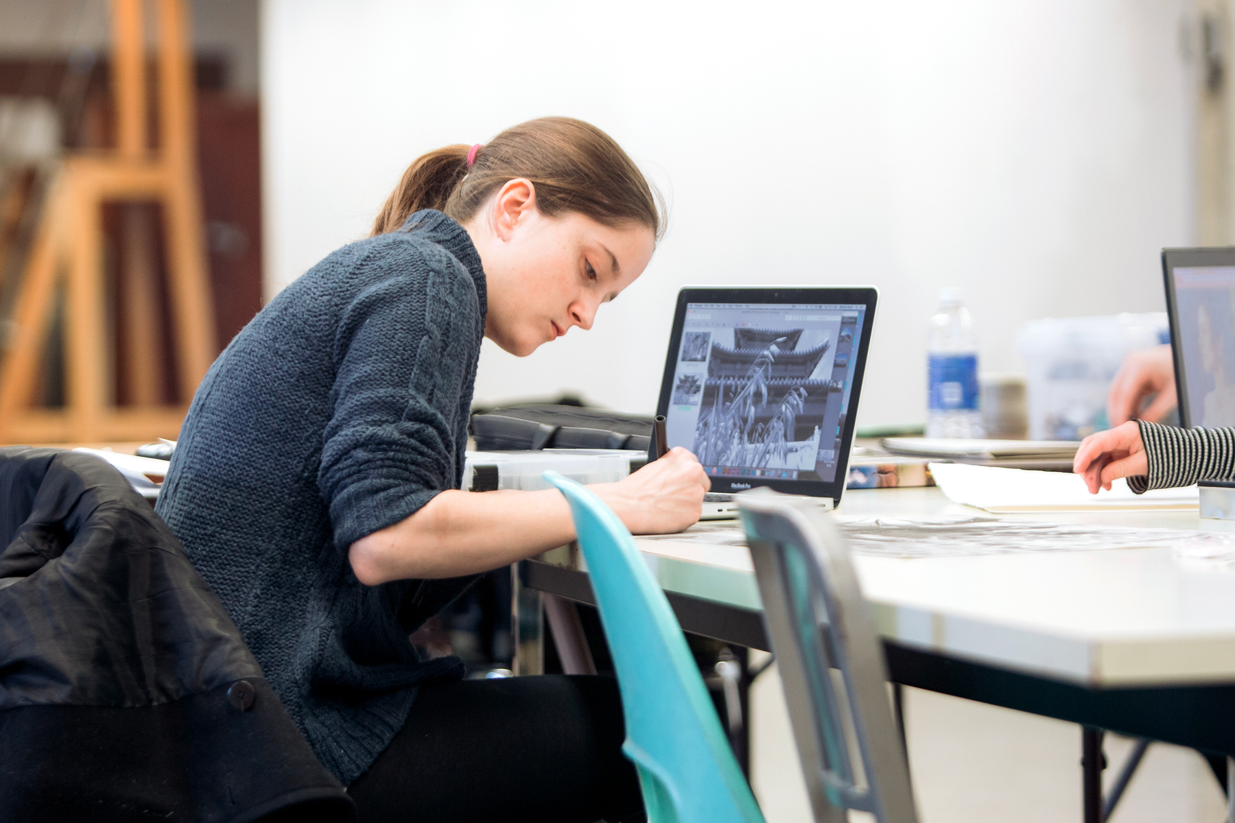 Working on a capstone project, a Drake Art History major goes between their notepad and their laptop