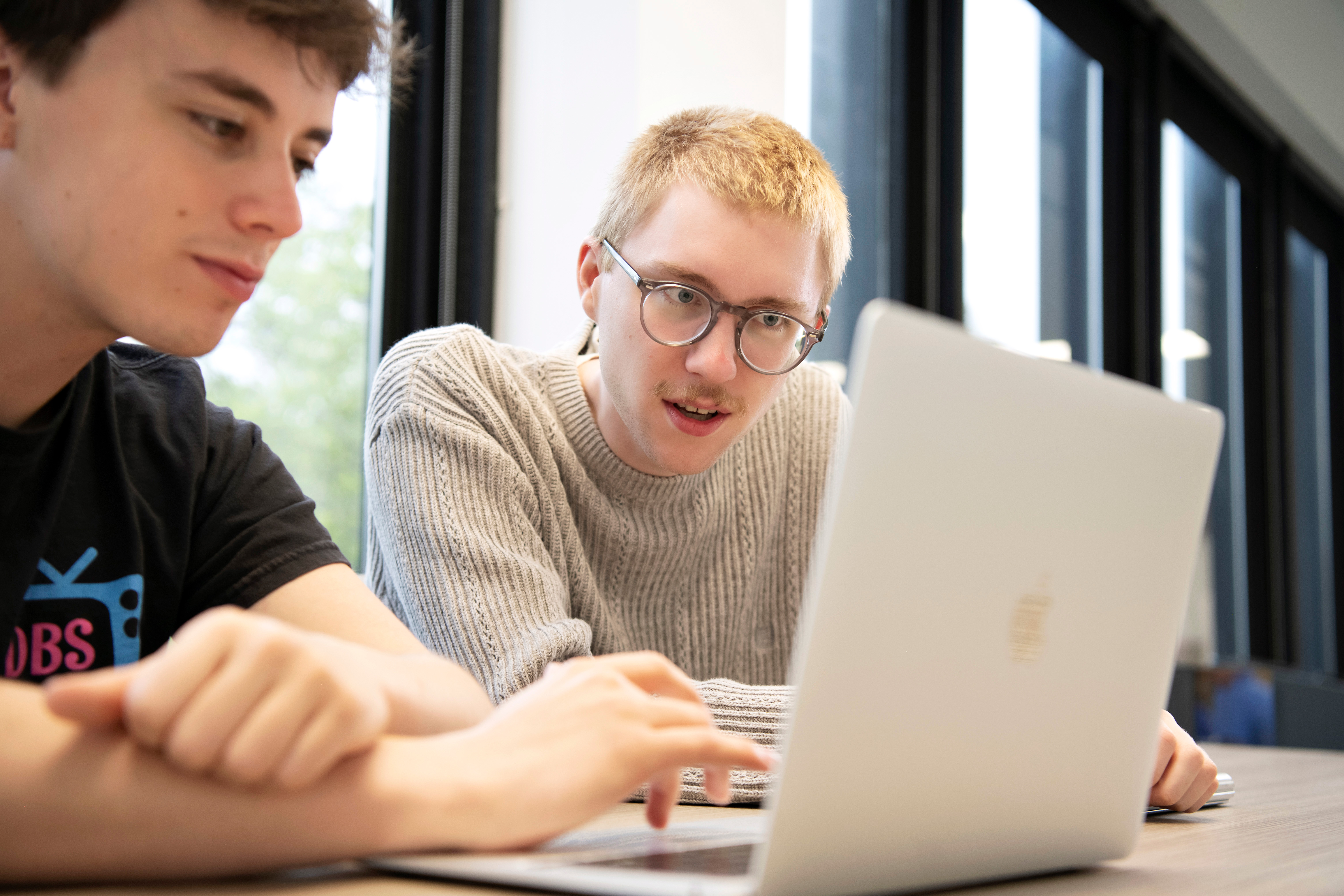 Two Drake Biochemistry, Cell, and Molecular Biology students examine research data on a laptop