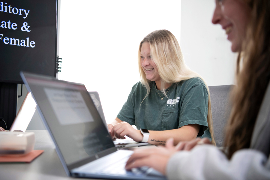 Students participating in Drake's Behavior Analysis of Developmental Disabilities program review slides for a research presentation