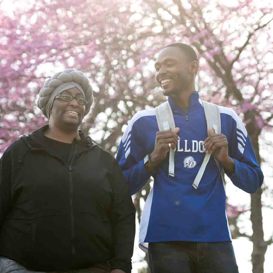 Students from Drake's Black Diaspora Studies program walk below cherry blossom trees outdoors