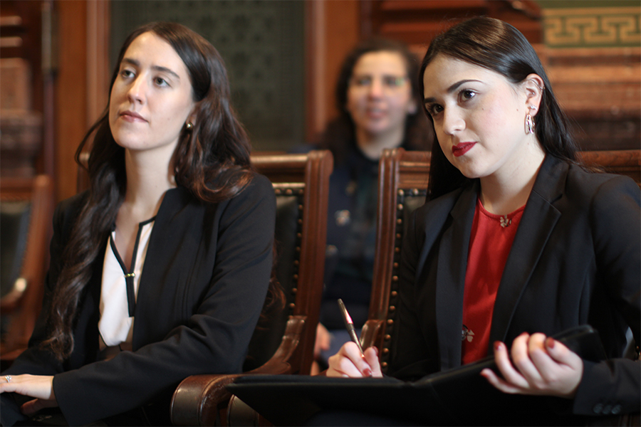 Two Drake Business/Law 3+3 students in dress clothes observe legal professionals during the First-Year Trial Practicum court