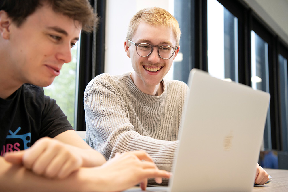 Two Computer Science students from Drake meet around a laptop to work on a research project