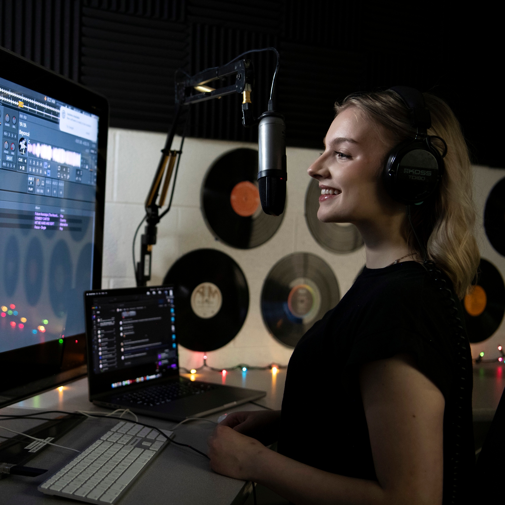 A Drake Digital Media Production major speaks into a microphone in a campus recording studio