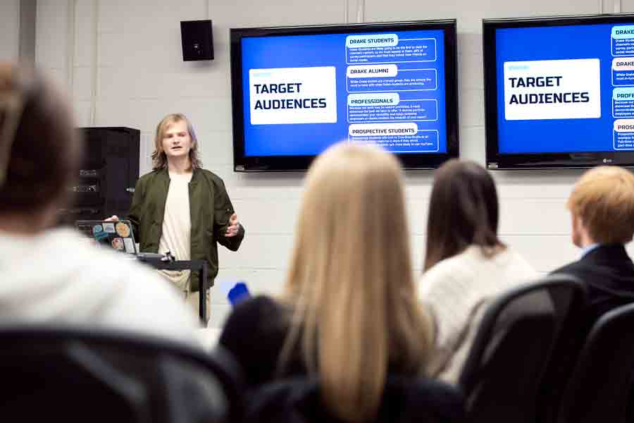 In one of the campus's professional student organizations, a Digital Media Production student at Drake presents their campaign project to a group of peers