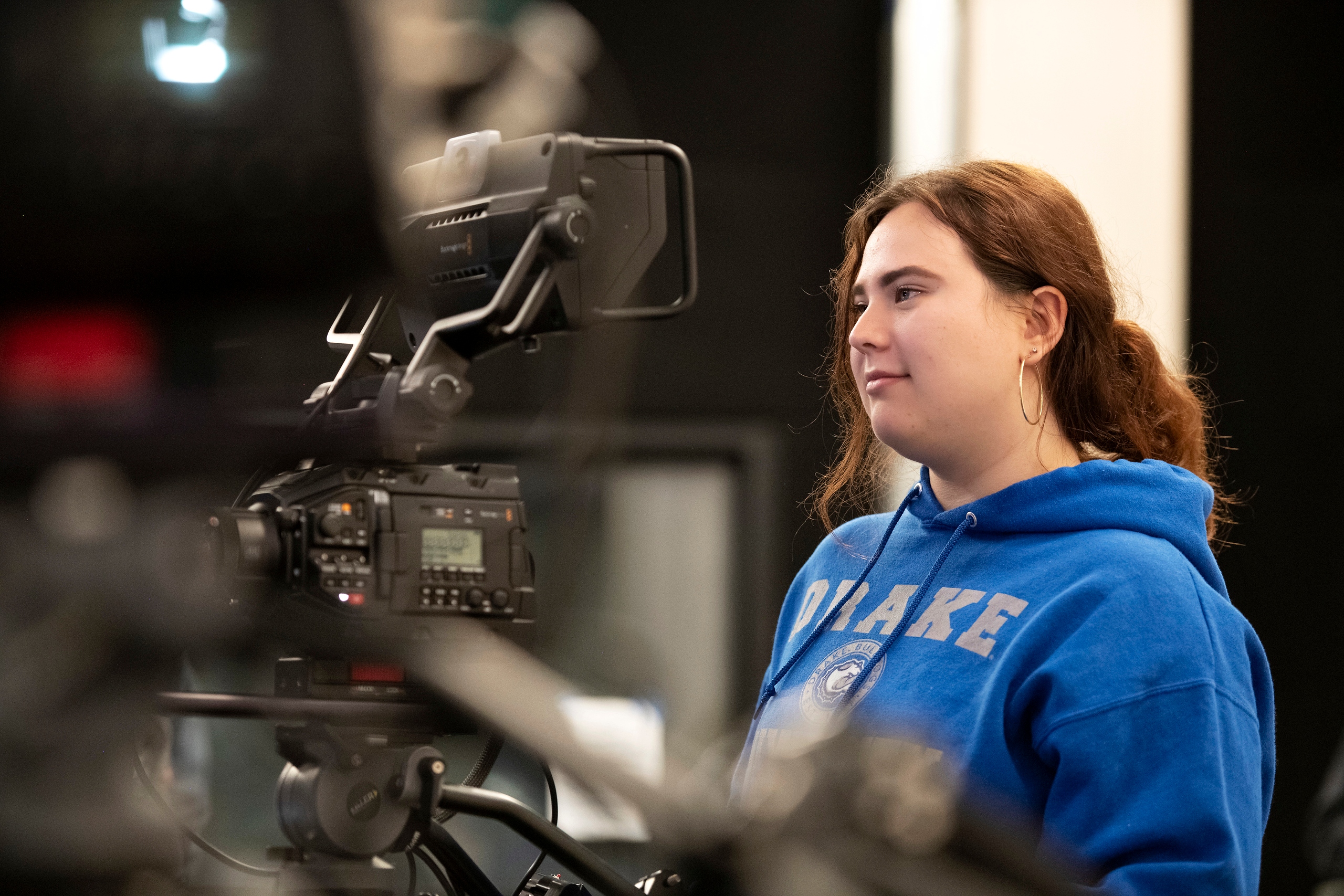 A Drake University Digital Media Production Major learns to use a camera in an on-campus film studio