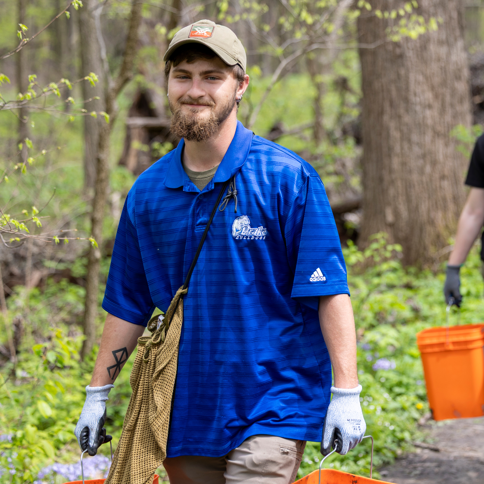 A Drake Environmental Science student moves buckets of soil during a community tree planting project
