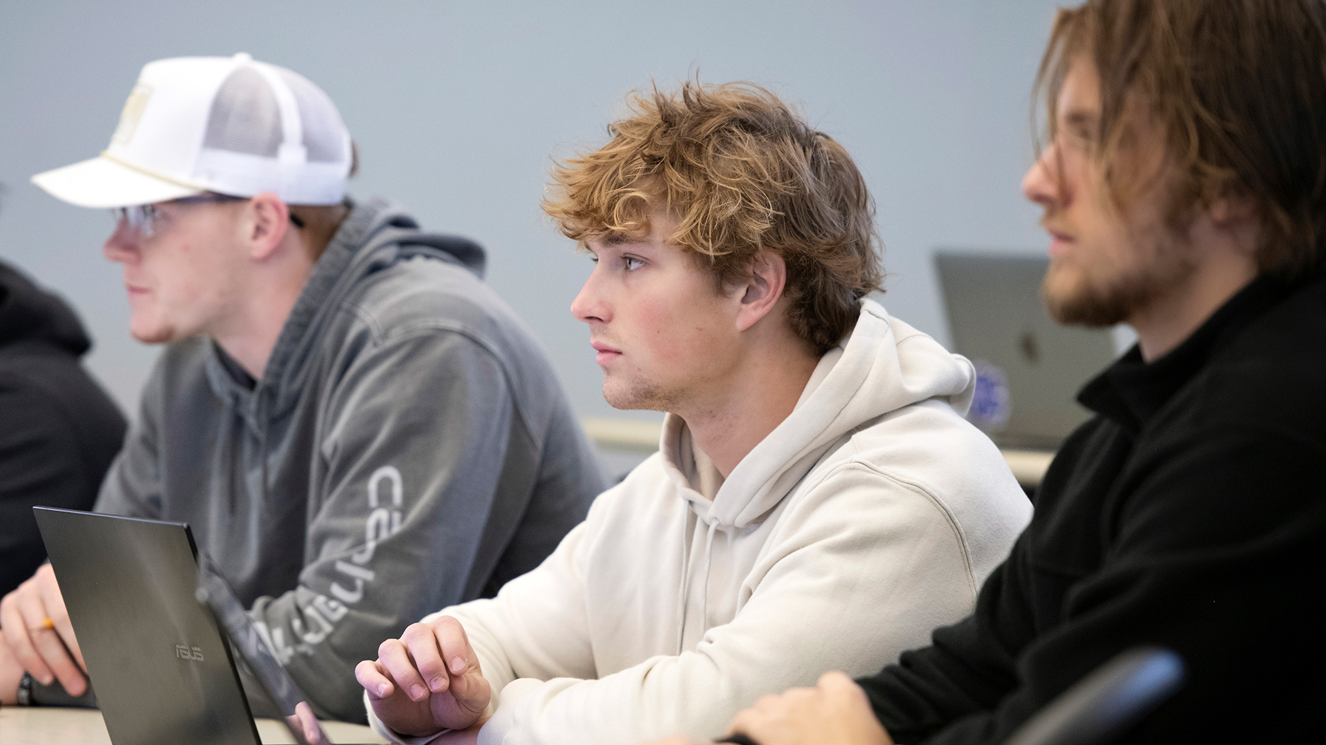 Finance majors at Drake lean in to observe a classroom lecture from behind a desk