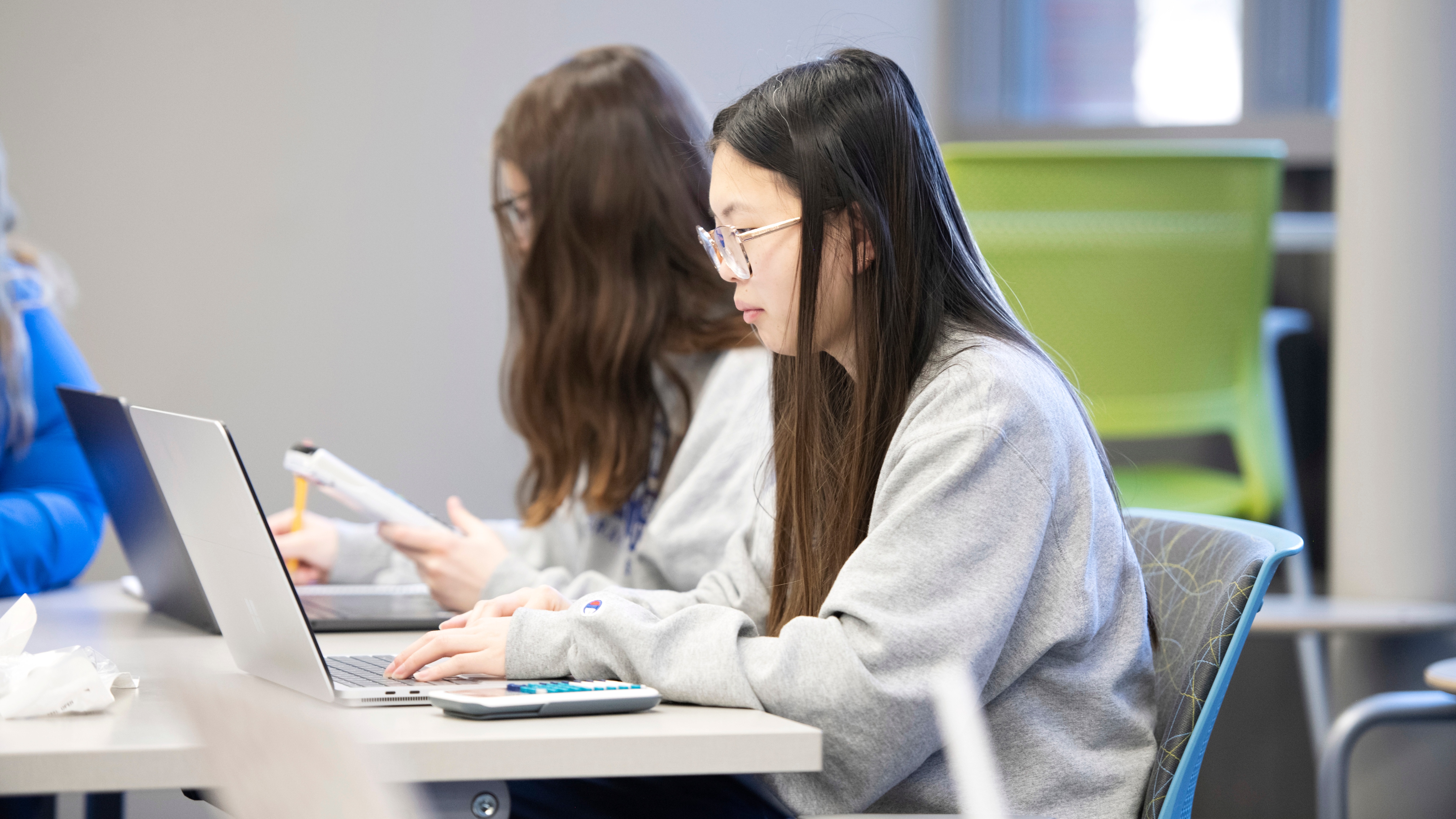 Drake students in a class for the Global and Comparative Public Health Concentration analyze data on a computer with calculators