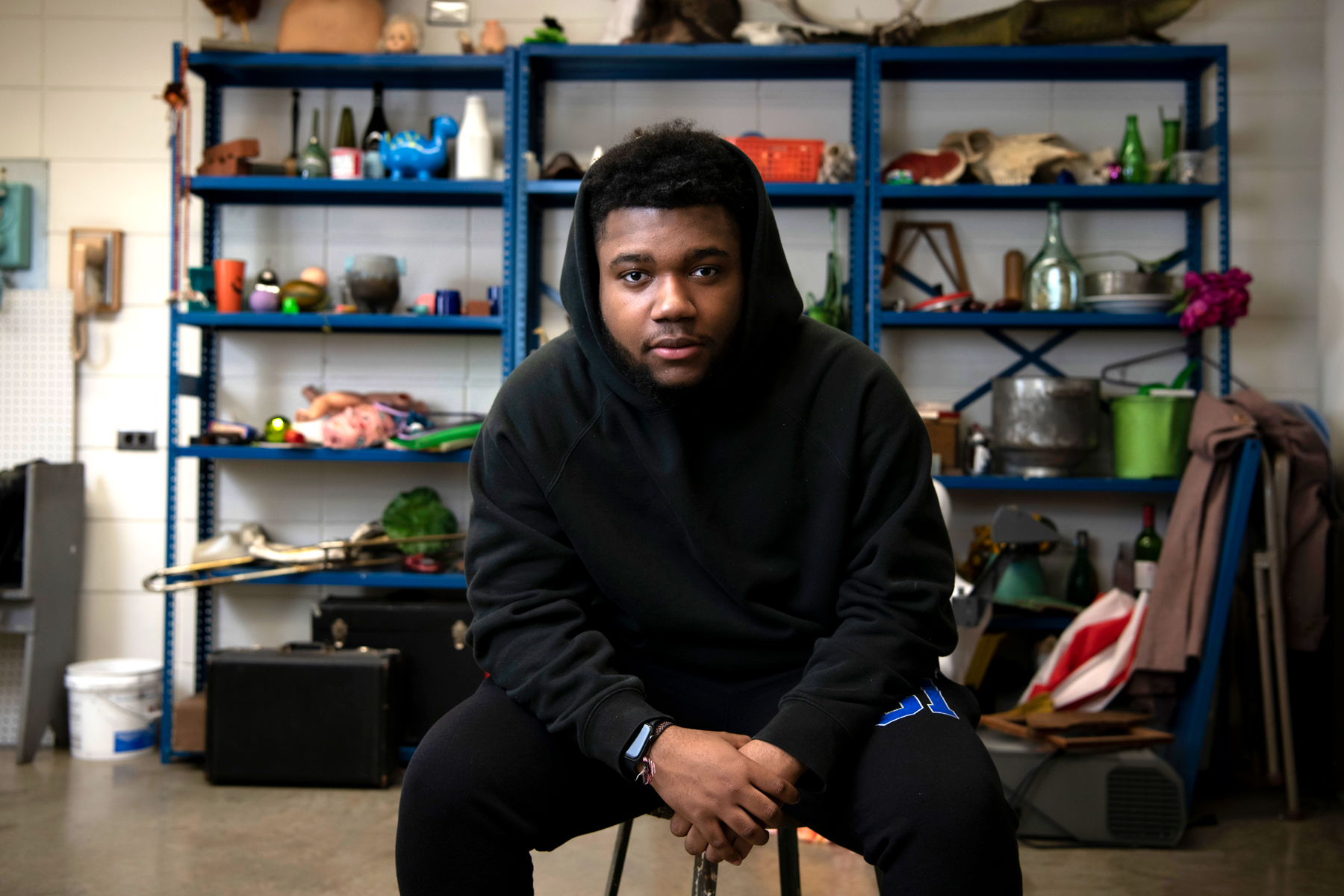 A Drake Graphic Design student sits on a stool in a campus studio