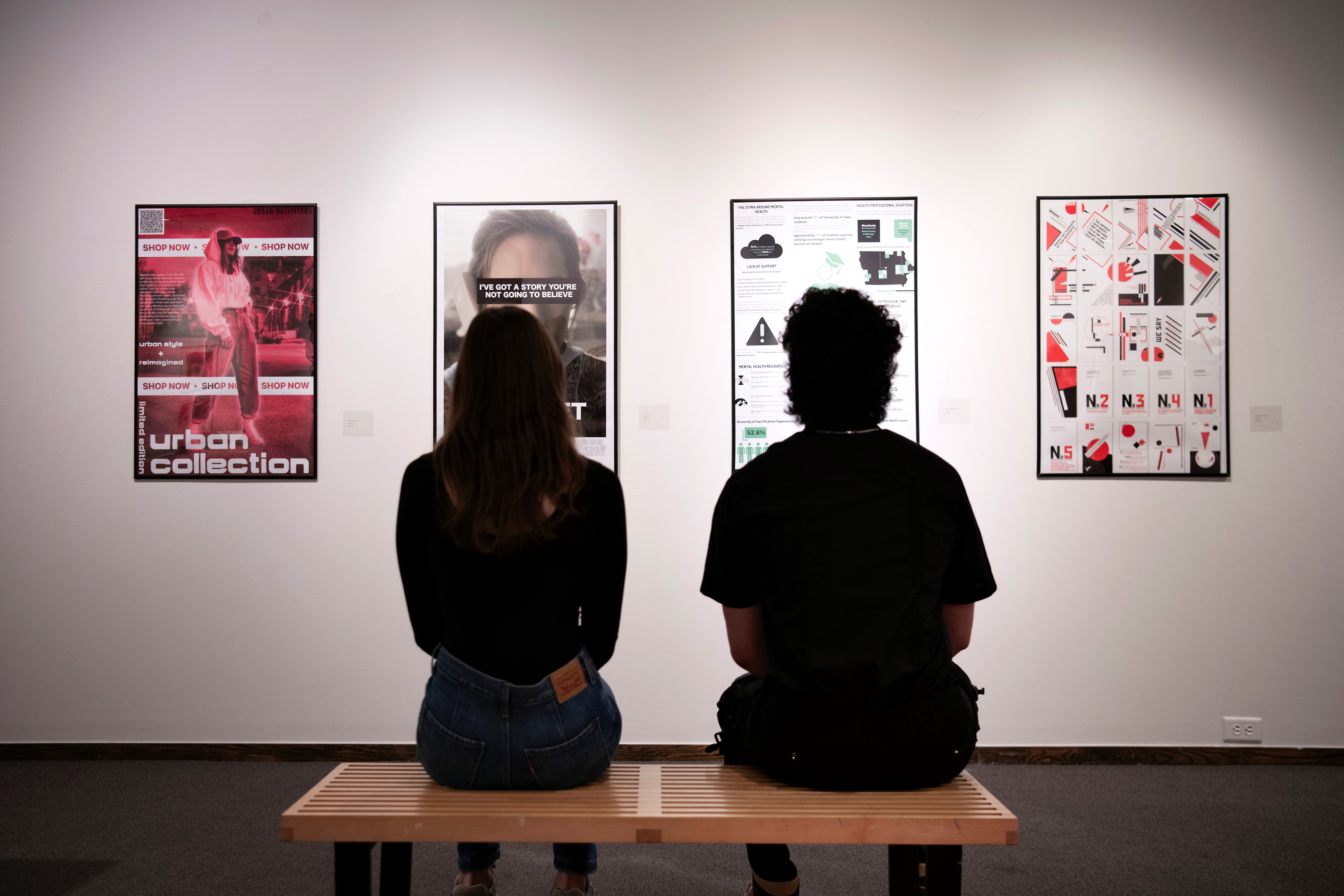 Two Graphic Design students study an exhibit in one of Drake University's galleries
