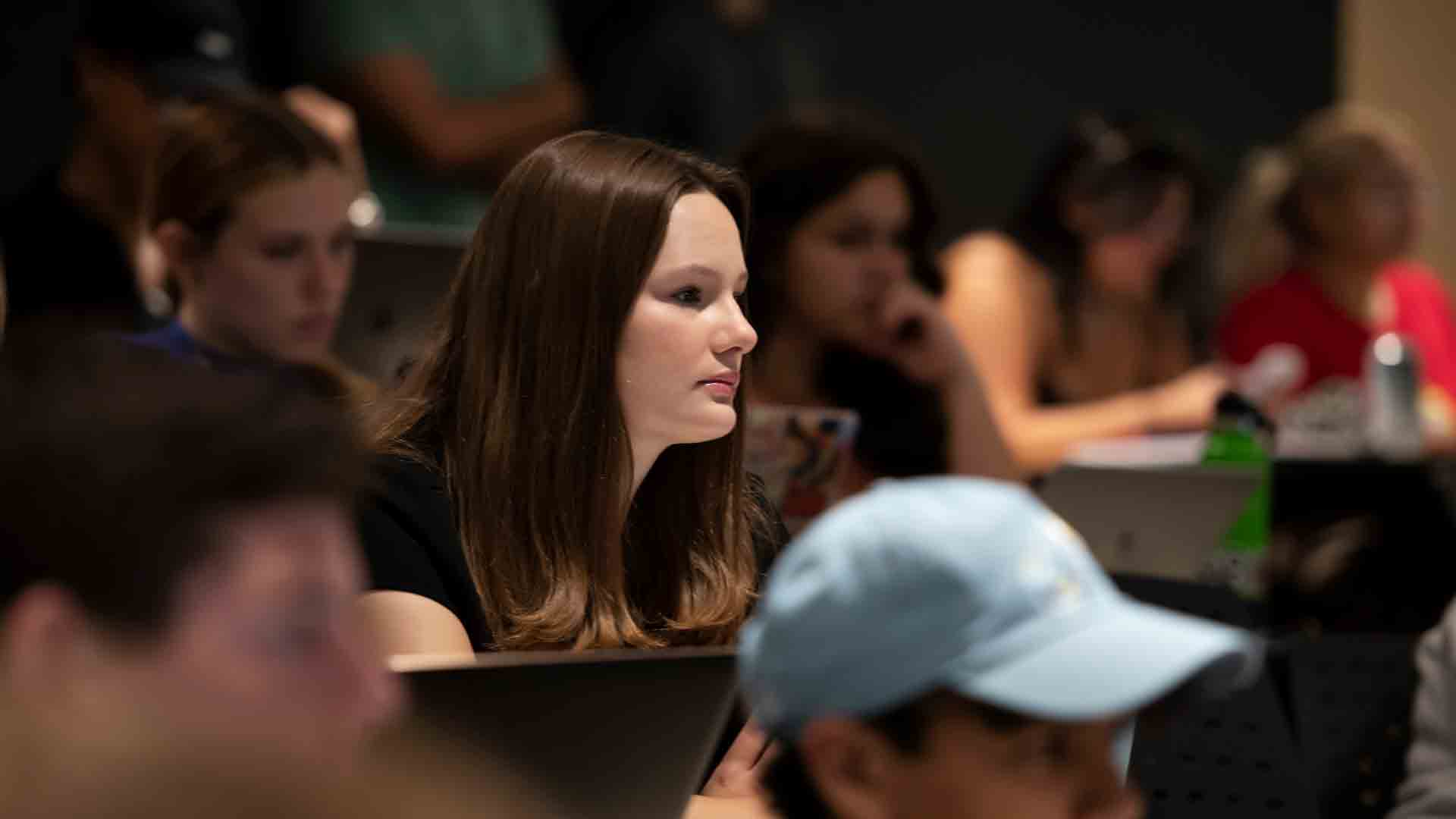 Drake students in a large class intently listen to a history professor's lecture