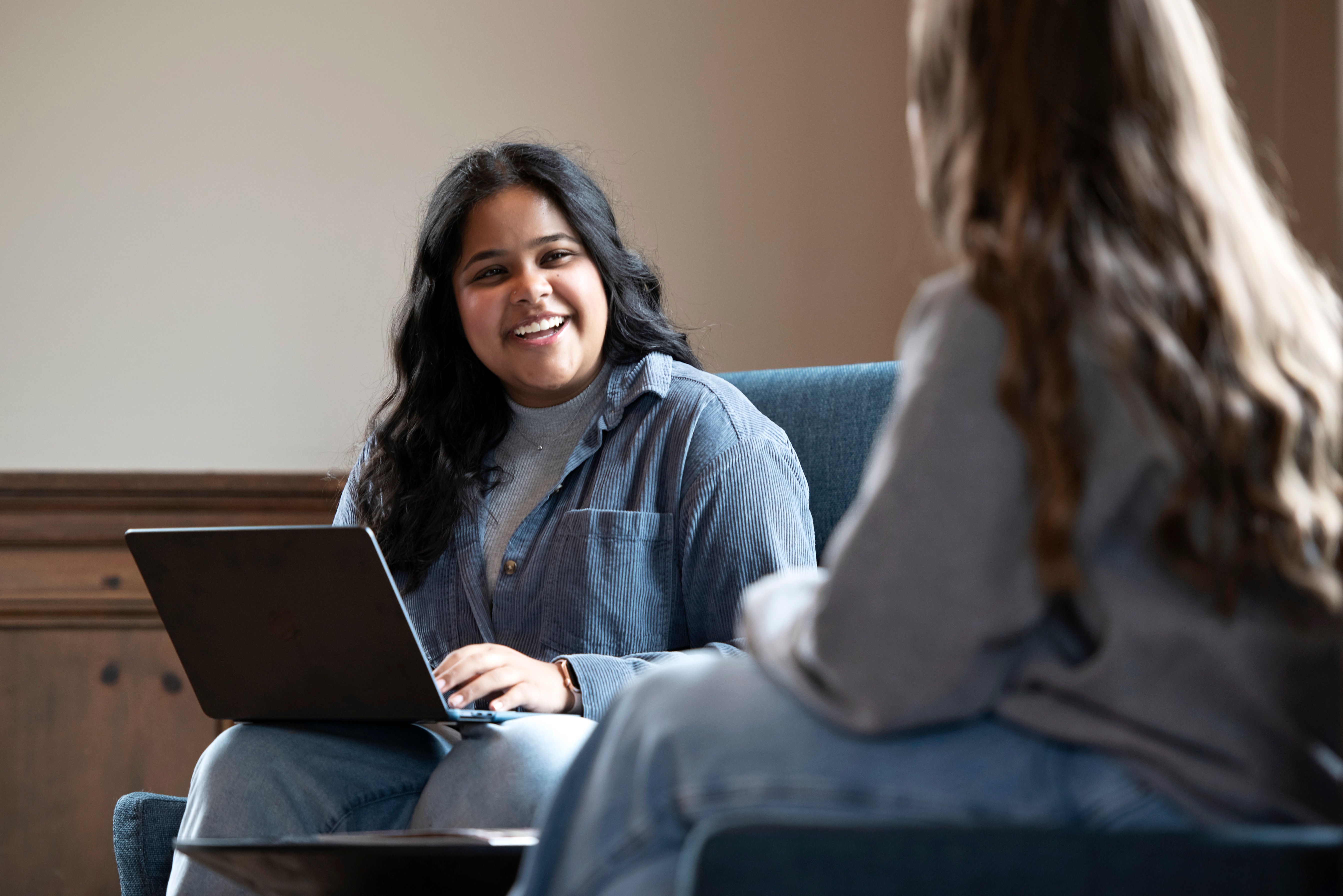 Sitting in a common area, two Drake students discuss career options in the human resources management field