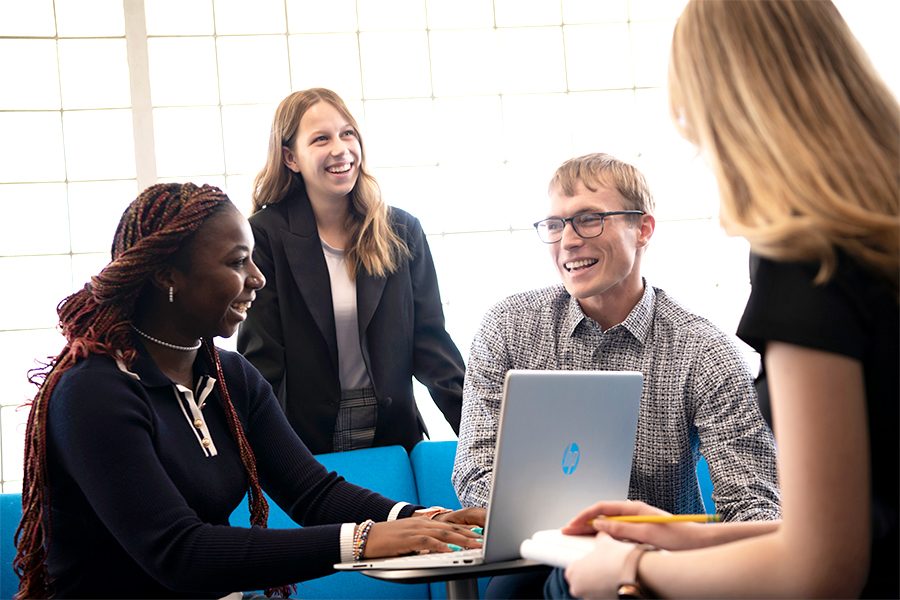 Drake International Business students sit around a table in a common area to collaborate on a research project